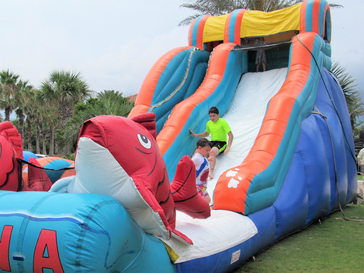 Two boys slide down a water slide in the festival's Kids' Zone.